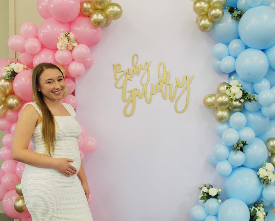 Gender reveal baby shower with pink and blue balloon arch