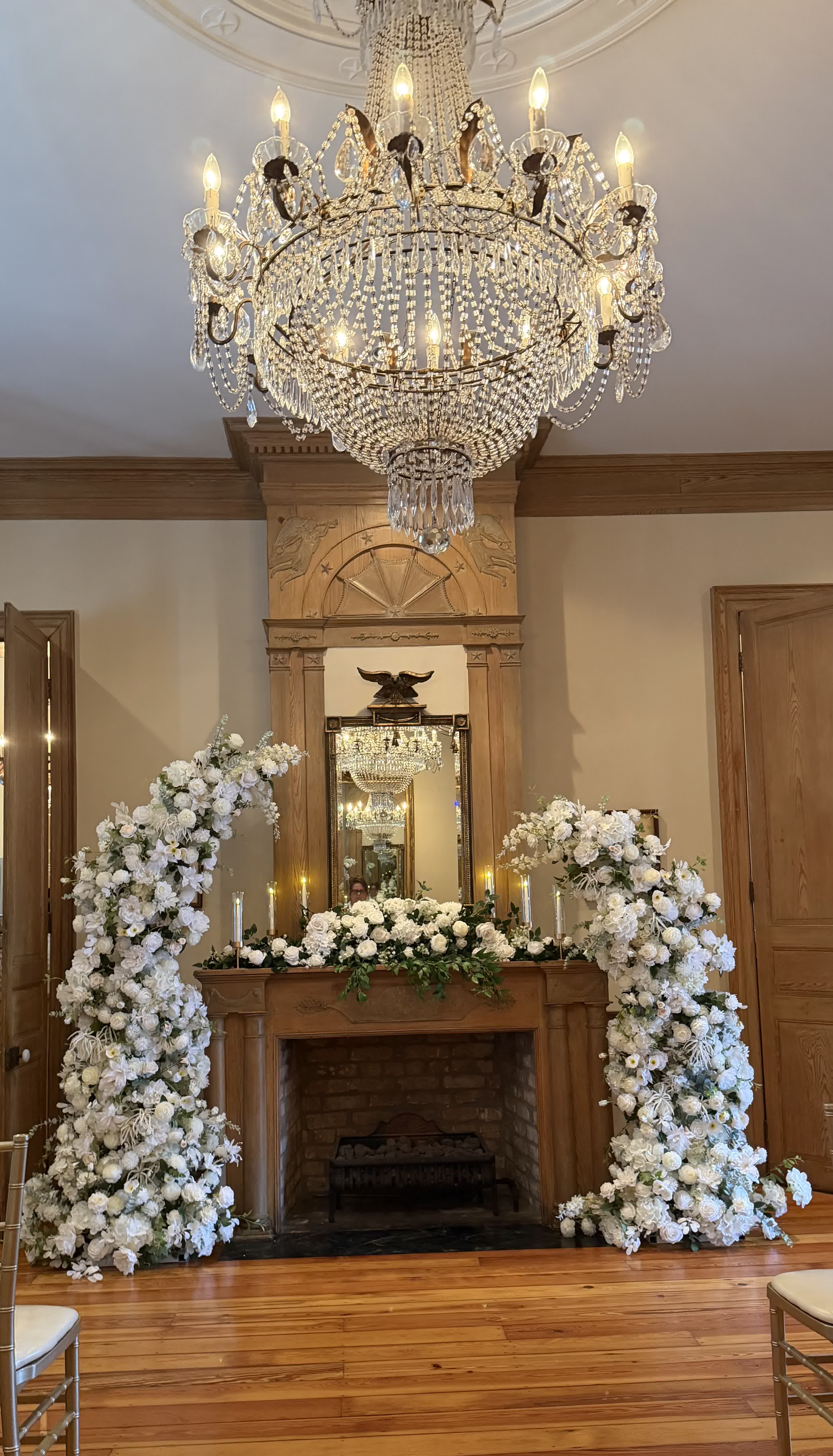 Lush white floral arch framing doorway with checkerboard floor